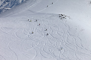 Image showing Snowboarders and skiers downhill on off piste slope.