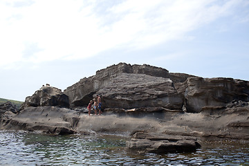 Image showing Father and children on cliff