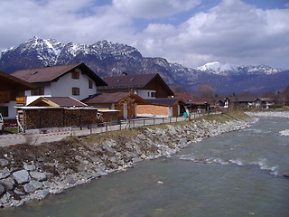 Image showing Alpine cottages by a river