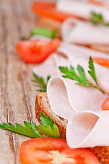 Image showing bread with sliced ham, fresh tomatoes and parsley