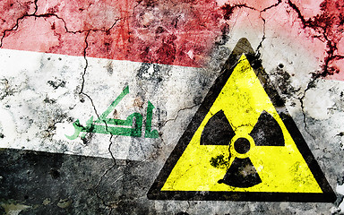 Image showing Old cracked wall with radiation warning sign and painted flag