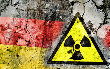 Image showing Old cracked wall with radiation warning sign and painted flag