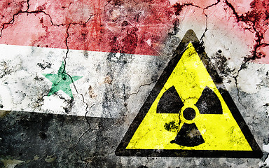 Image showing Old cracked wall with radiation warning sign and painted flag