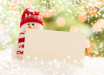 Image showing Snowman with Blank White Card Over Abstract Snow and LIght