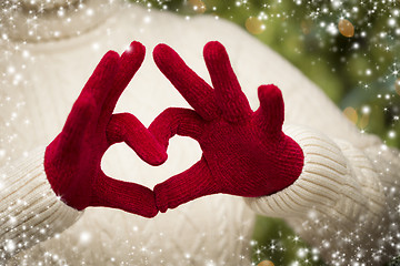 Image showing Woman Wearing Red Mittens Holding Out a Heart Hand Sign