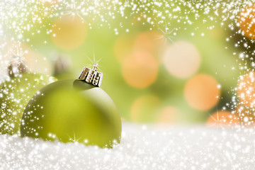 Image showing Green Christmas Ornaments on Snow Over an Abstract Background