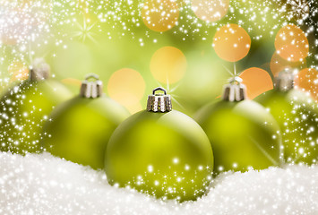 Image showing Green Christmas Ornaments on Snow Over an Abstract Background