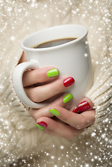 Image showing Woman with Red and Green Nail Polish Holding Cup of Coffee