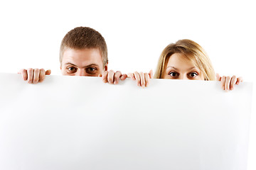 Image showing couple peeking out from behind the booth