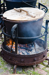 Image showing old pot for cooking over a campfire, close-up. 