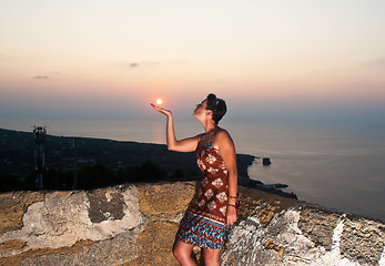 Image showing Girl kissing sun at sunset