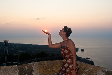 Image showing Girl kissing sun at sunset