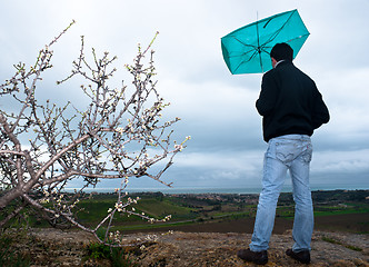 Image showing Man with an umbrella look rainstorm clouds