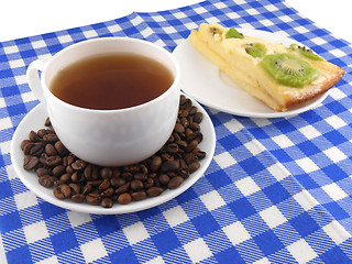 Image showing A cup of coffee and a piece of tasty creamy cake with coffee beans