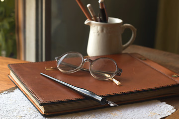 Image showing Busines concept with retro glasses, notebook, ink pen on wooden background