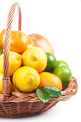 Image showing Fresh citrus fruit with leaves in a wicker basket