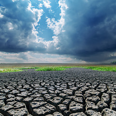 Image showing global warming. cracked earth and dark clouds