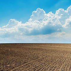 Image showing plowed field in spring and clouds over it