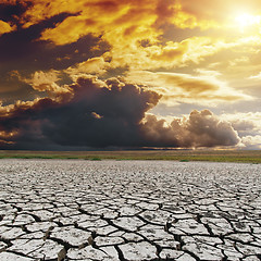 Image showing orange dark sunset over drought earth. global warming