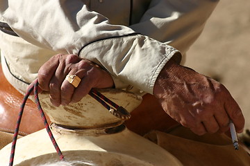 Image showing Hands of cowboy with cigarette