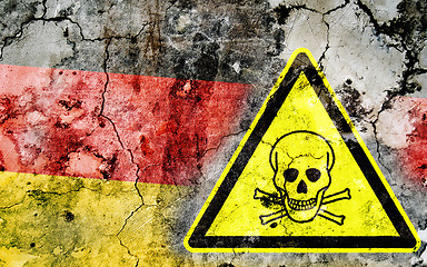 Image showing Old cracked wall with poison warning sign and painted flag