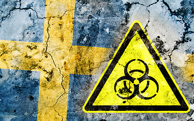 Image showing Old cracked wall with biohazard warning sign and painted flag