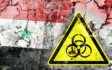 Image showing Old cracked wall with biohazard warning sign and painted flag