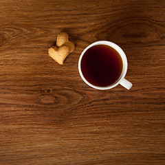 Image showing hot cup of tea with cookies on wooden table