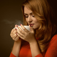 Image showing woman holding hot cup and smiles