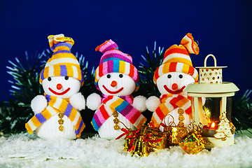 Image showing Three snowman with a lantern
