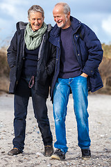 Image showing happy elderly senior couple walking on beach