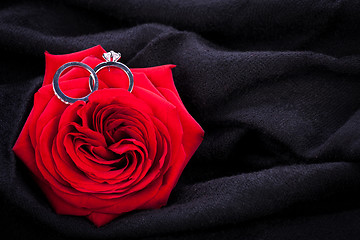 Image showing Diamond engagement ring in the heart of a red rose