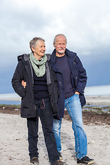 Image showing happy elderly senior couple walking on beach