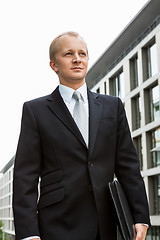 Image showing smiling successful business man in black suit outdoor