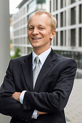 Image showing smiling successful business man in black suit outdoor