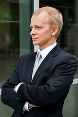 Image showing smiling successful business man in black suit outdoor