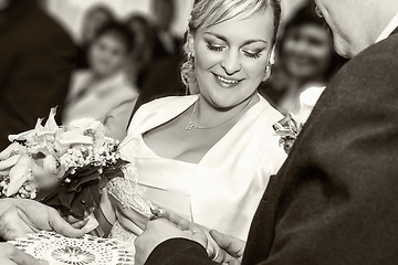 Image showing Groom Happy putting ring on smiling pretty woman bride's finger