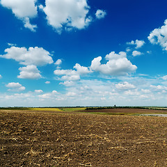 Image showing blue cloudy sky over plowed field