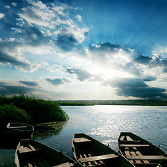 Image showing boats on river and sunset over it