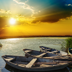 Image showing yellow sunset over river with boats