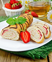 Image showing Roulade a cup of tea and strawberries on a board