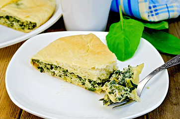 Image showing Pie with spinach and cheese with a fork on a board