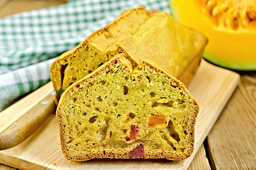 Image showing Fruitcake pumpkin with candied fruit and a napkin on a board