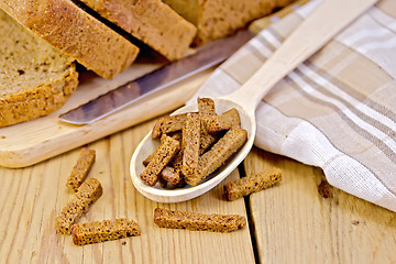 Image showing Rye homemade bread with croutons in spoon on a board