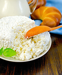 Image showing Curd on a saucer with a spoon on a board