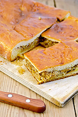 Image showing Pie with cabbage and mushrooms on a board with a knife