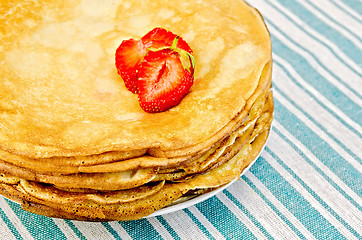 Image showing Pancakes on a plate with strawberries on a napkin