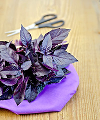 Image showing Basil purple with scissors on a board