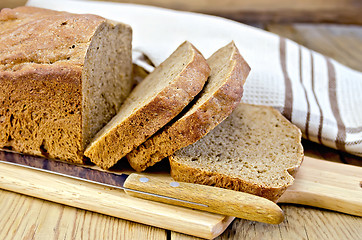 Image showing Rye homemade bread sliced on the board with a napkin