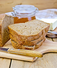 Image showing Rye homemade bread stacked with honey on a board